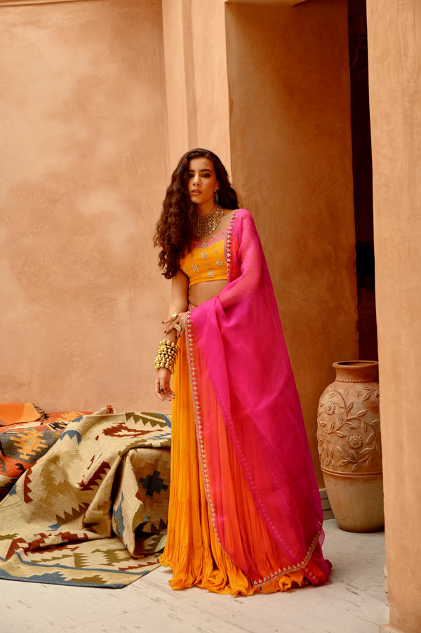 Turmeric yellow tier lehenga with blouse and dupatta.