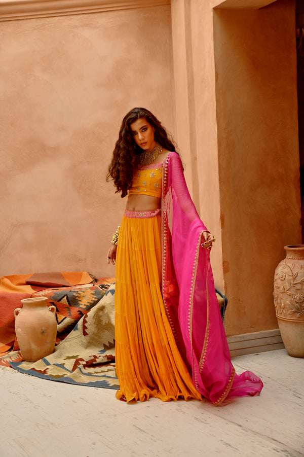 Turmeric yellow tier lehenga with blouse and dupatta.